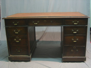 A Victorian oak kneehole pedestal desk with inset tooled leather writing surface above 1 long and 8 short drawers 56"