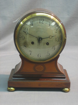 An Edwardian 8 day striking mantel clock with silvered dial and Arabic numerals contained in an inlaid mahogany balloon case, raised on 4 bun feet by Potts & Sons of Leeds