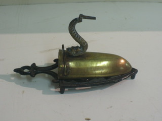 A small 19th Century brass flat iron complete with slug, the handle in the form of a dolphin, complete with stand 3"