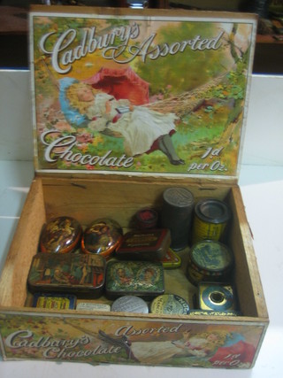 A wooden Cadbury's chocolate box with hinged lid containing 20 various tins