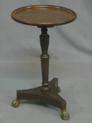 A Victorian mahogany dish top wine table, raised on a turned column and triform base with iron paw feet 13"