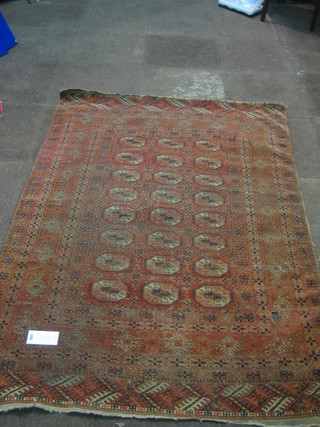 A red ground Bokhara rug with 24 octagons to the centre (slight hole and worn) 67" x 49"