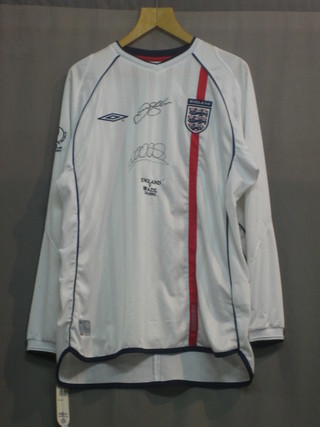 A white Umbro England Football shirt specially sold for the England V Brazil 2002 World Cup game, signed by David Beckham and Michael Owen, with Auctionworld Ltd certificate of authenticity (size XL)