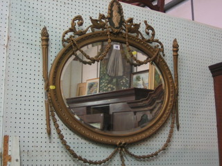 A 19th Century oval bevelled plate wall mirror contained in a gilt frame surmounted by half a standing lady 29" (some damage)