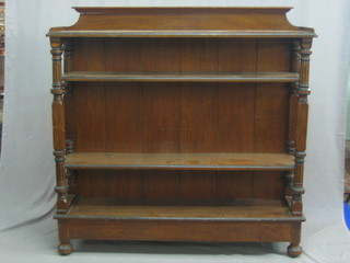 A Victorian oak open 3 tier bookcase, raised on turned and fluted columns raised on bun feet 54"