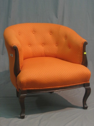 A pair of Victorian mahogany framed tub back armchairs upholstered in orange material, raised on cabriole supports