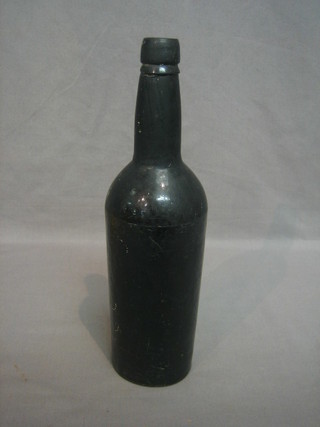 An antique black glass bottle