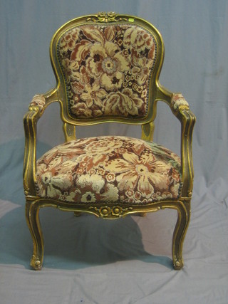 A pair of French style gilt open arm salon chairs with upholstered seats and backs raised on cabriole supports