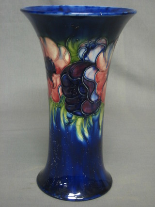 A Moorcroft blue glazed vase of waisted cylindrical form with anemone pattern, the base with signature mark and impressed Potter to HM The Queen, Made in England, 11" (slight crack)