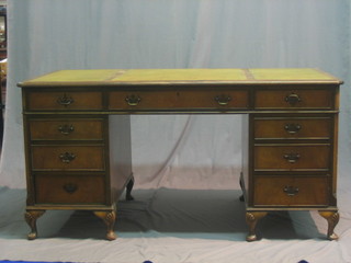 A walnut kneehole pedestal desk with green inset tooled leather writing surface above 1 long and 8 short drawers, raised on cabriole supports 60"