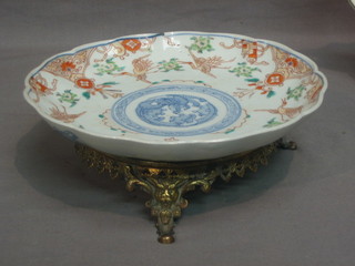 A circular Japanese Imari porcelain bowl with lobed body decorated birds, raised on a metal base 8 1/2"