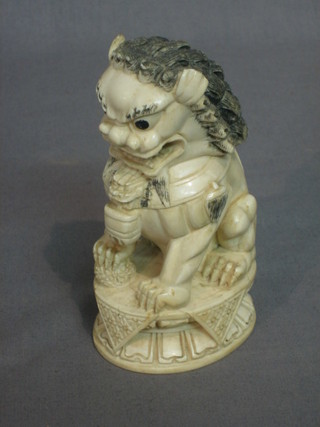 A carved Eastern ivory figure of a seated Dog of Fo, the base with seal mark 5"