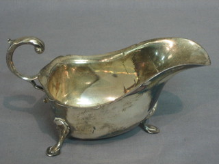 A Georgian style silver sauce boat with wavy border and C scroll handle, raised on 3 hoof feet, London 1967, 6 ozs