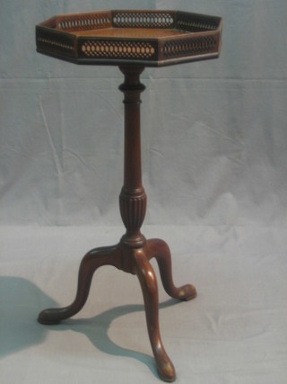 A Georgian style octagonal mahogany wine table with pierced gallery, raised on pillar and tripod supports 15"