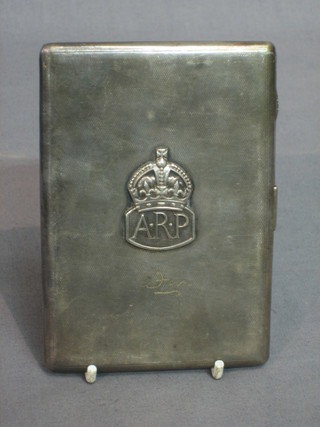 A silver cigarette case London 1934, the front with ARP badge 6 ozs