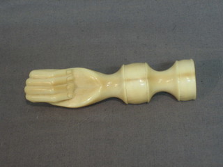 A turned ivory seal in the form of a clasped fist (thumb f) 4"
