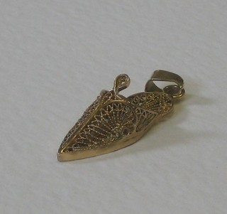A filigree gold charm in the form of a Turkish slipper