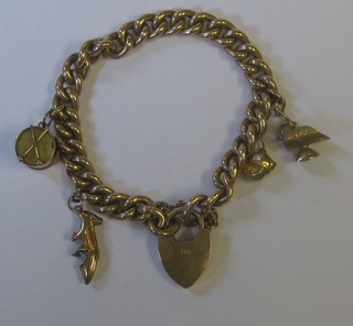 A 9ct gold curb link bracelet with padlock clasp hung 4 various charms