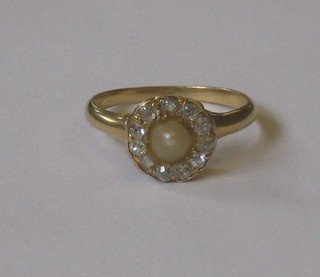 An Edwardian gold dress ring set a pearl surround by diamonds
