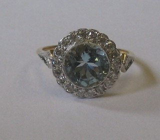 A lady's 18ct yellow gold dress ring set a circular aquamarine surrounded by numerous diamonds, approx 0.30/1.58ct