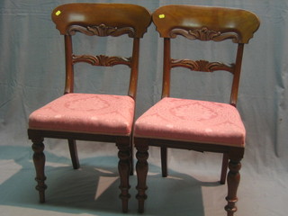 A pair of William IV mahogany bar back dining chairs with carved mid rails and upholstered seats, raised on turned supports