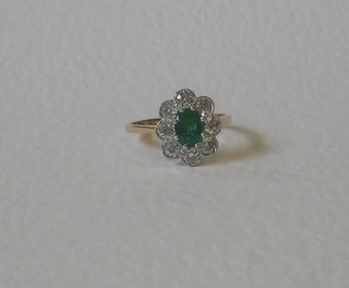 A lady's 18ct yellow gold dress ring set an oval cut emerald surrounded by 8 diamonds approx 0.95ct