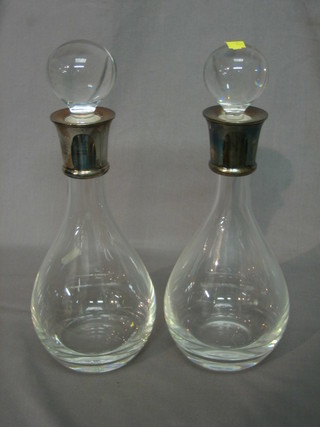 A pair of modern club shaped decanters with silver collars