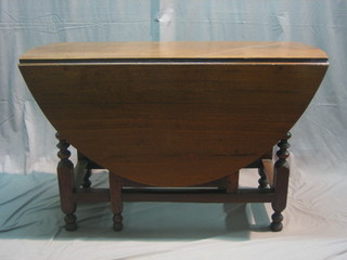 A 17th Century style honey oak gateleg dining table fitted a drawer, raised on bobbin turned supports 48"