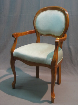 A Victorian style open arm chair upholstered in turquoise material and raised on cabriole supports