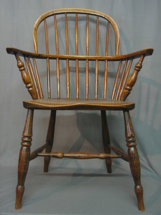 An elm comb back kitchen carver chair with solid elm seat, raised on turned supports