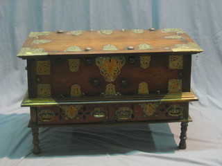 A 19th Century Eastern hardwood coffer on stand with hinged lid, the base fitted 2 long drawers, raised on turned supports heavily studded and with pierced metal embellishments throughout 33"