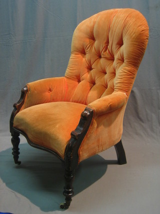 A Victorian mahogany show framed armchair upholstered in pink buttoned material raised on turned supports