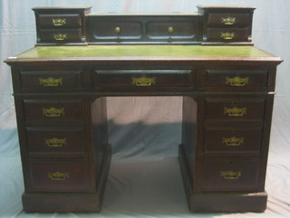 A Victorian oak desk with raised super structure to the back, fitted a stationery compartment, flanked by 4 short drawers with green inset tooled leather writing surface above 1 long and 8 short drawers 48"