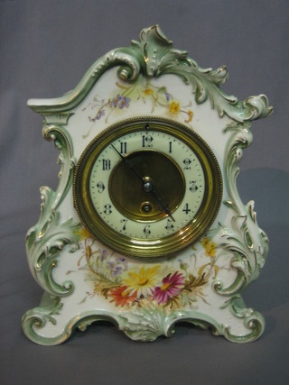 A Victorian mantel clock with enamelled dial  contained in a floral pottery case