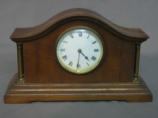 A 1930's bedroom timepiece with enamelled dial and Roman Numerals contained in an arched mahogany case