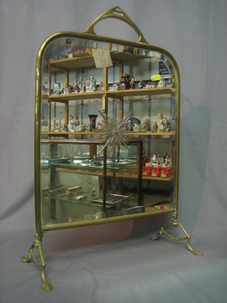 A Victorian mirrored fire screen contained in a brass frame