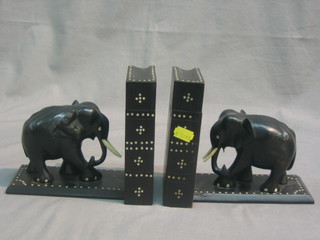 A pair of ebony and inlaid ivory book ends in the form of elephants with secret compartment