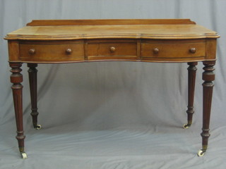 A Victorian shaped bleached mahogany dressing table of serpentine outline, fitted 1 short and 2 long drawers, raised on turned and fluted supports 47"