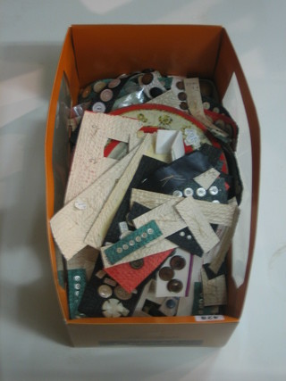 A circular biscuit tin containing a collection of various buttons and a box of buttons