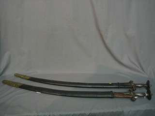 A pair of Eastern swords with etched blades and scabbards 