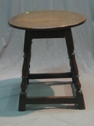 A circular oak occasional table, raised on turned and block supports 21"