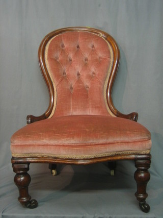 A Victorian mahogany show frame armchair upholstered in pink buttoned material, raised on turned supports