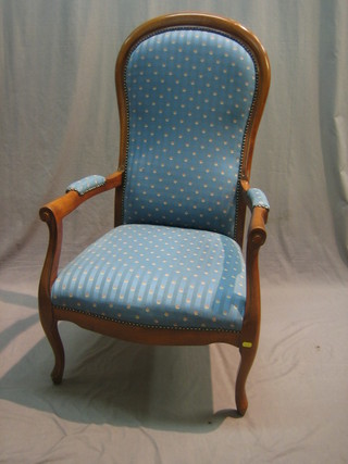 A pair of Victorian style mahogany open arm chairs upholstered in blue floral patterned material raised on cabriole supports