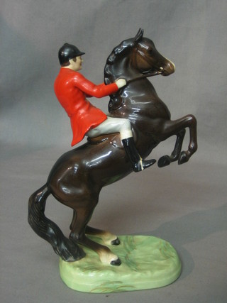 A Beswick figure of a hunter with red jacket on a rearing bay horse, base impressed Beswick England 868 9"