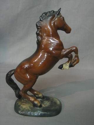 A Beswick figure of a rearing bay horse (right hoof f and r), raised on an oval naturalistic base, marked 1014 10"