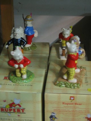 5 Royal Doulton Rupert The Bear Figures - Algy Pug Looking Like Robin Hood, Where Did You Get Such Fruit, Rupert and the Little Sea Sprite, Rupert Takes a Skiing Lesson, Pong Ping Leading the Way