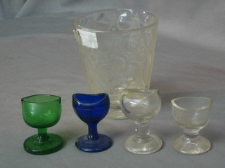 A 19th Century faceted glass beaker 5", a green glass eye bath, a blue glass eye bath and 2 clear glass eye baths