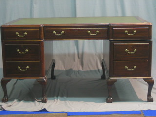 A mahogany inverted breakfront kneehole pedestal desk with green inset tooled leather writing surface, above 1 long and 4 short drawers, raised on cabriole supports 60"