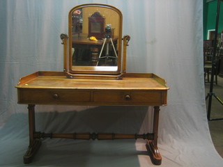 A Victorian mahogany dressing table with arch shaped plate mirror and three-quarter gallery fitted 2 long drawers, raised on standard end supports united by a turned stretcher 47"