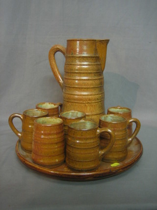 A French brown glazed pottery lemonade set comprising jug, 7 mugs and a tray, the base marked Greber Beauvais France